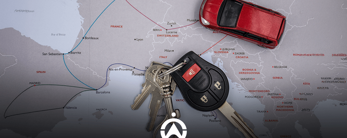 Car keys and a miniature red car on a European map background.