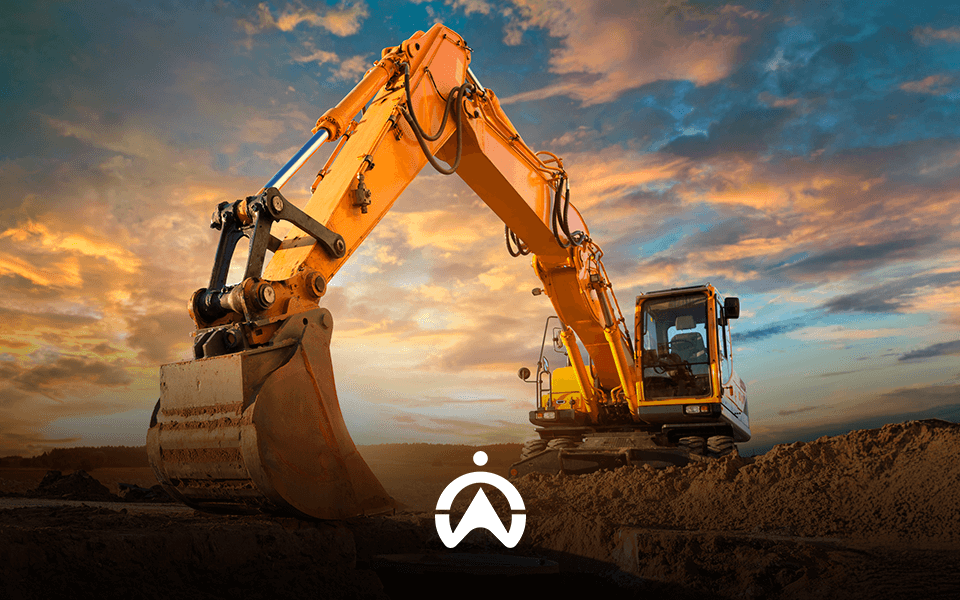 An orange excavator with a large bucket, set against a dramatic sunset sky, is positioned on a construction site.