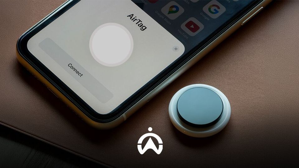 An iPhone displaying the "AirTag" setup screen next to an AirTag device, set on a leather surface.